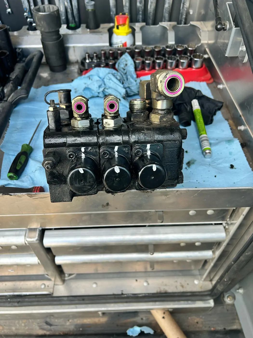 Three-section forklift hydraulic control valve on a shop workbench