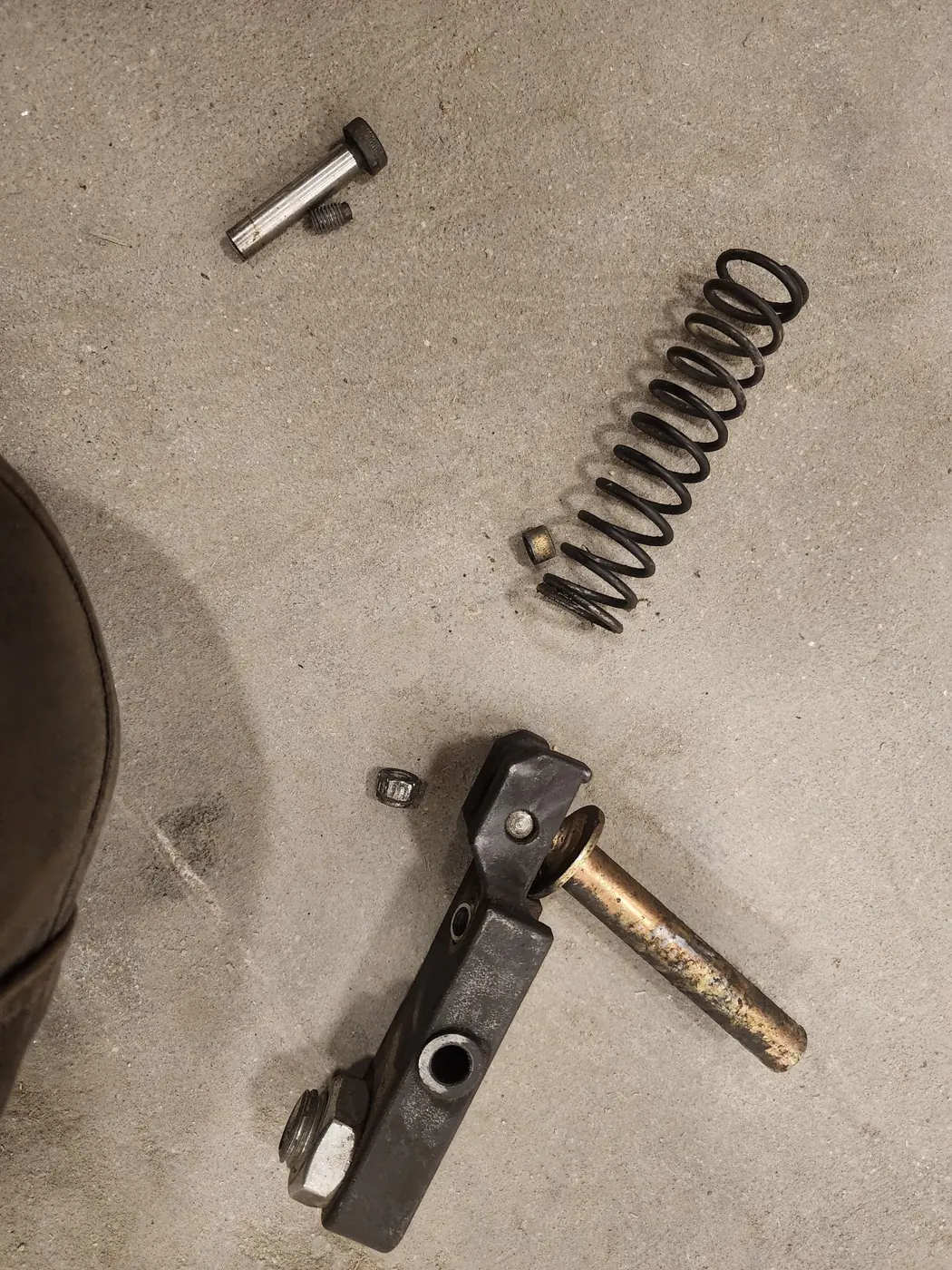 Spring, bracket, pins and nut arranged on the shop floor