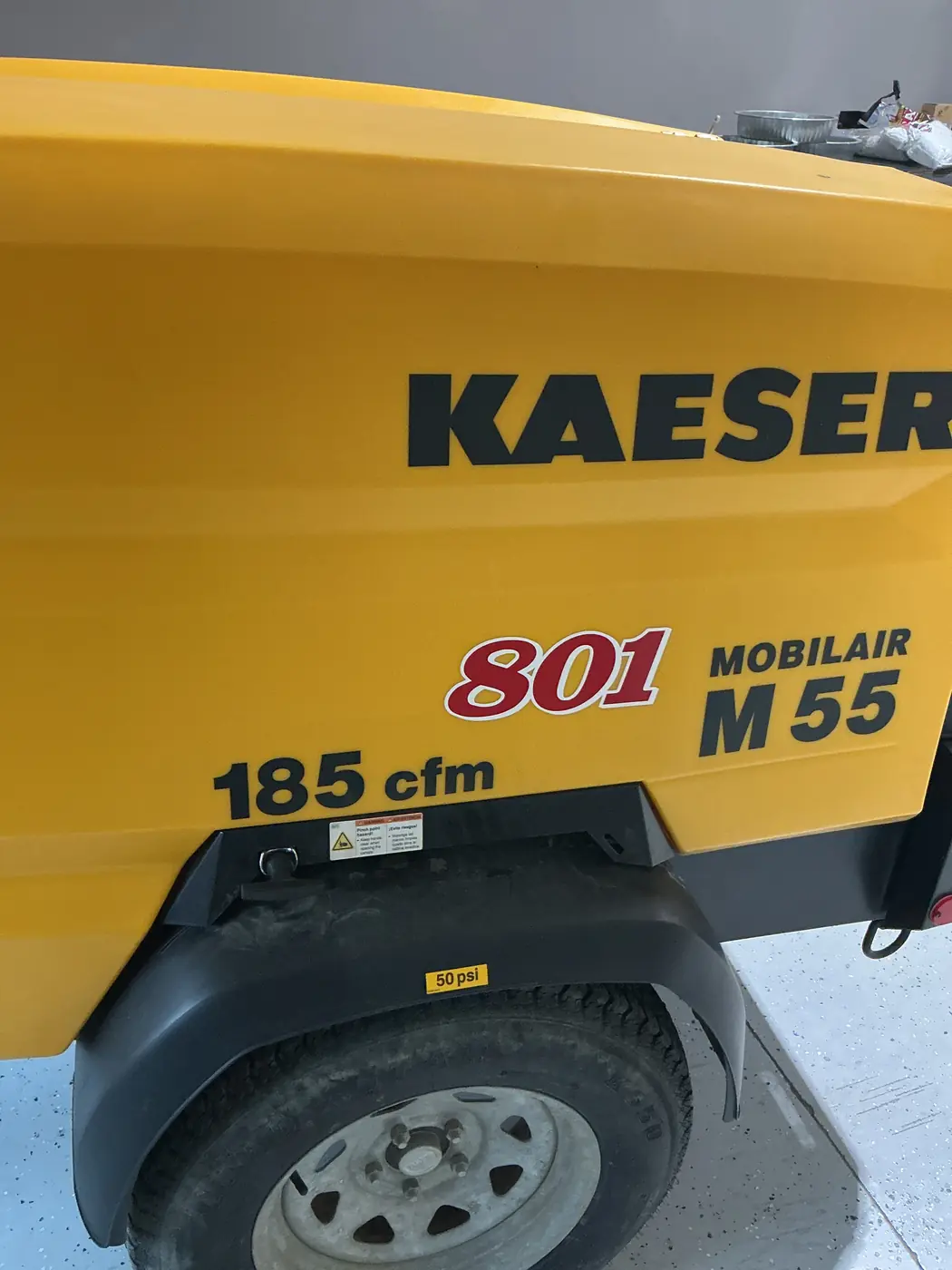 The yellow Kaeser Mobilair M55 towable compressor with its 185 cfm and Mobilair M55 decals