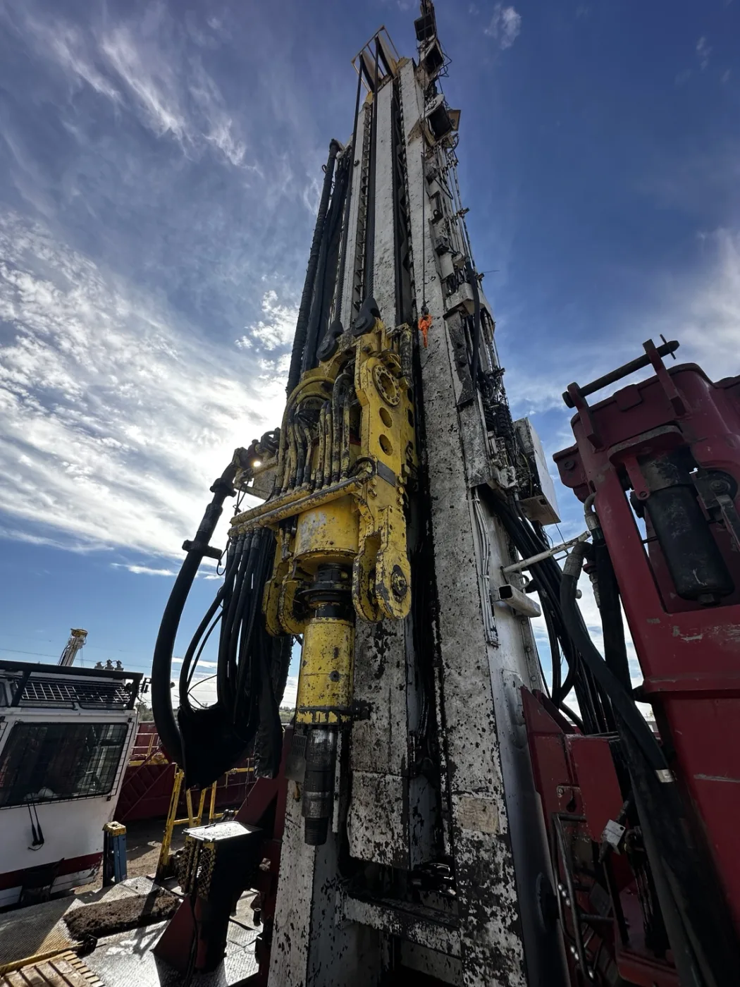 Yellow top drive and its hose bundle on the mast of the Schramm TXD500 drilling rig