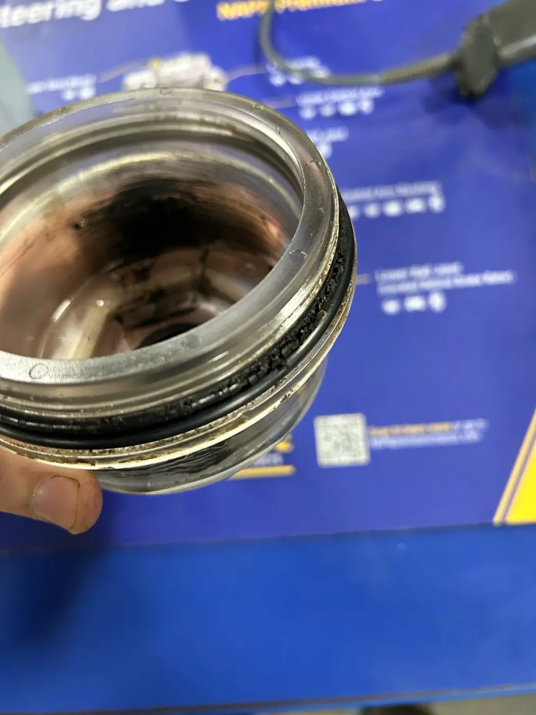Removed trailer hub cap with a dark, cracked O-ring still seated in its sealing groove