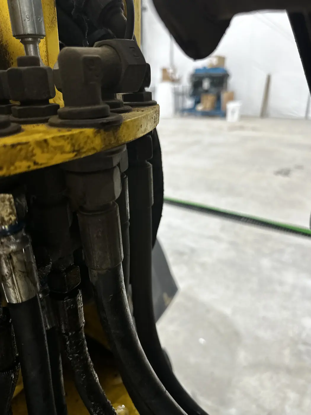Hydraulic hose ends and crimp fittings bolted through a bracket on the loader