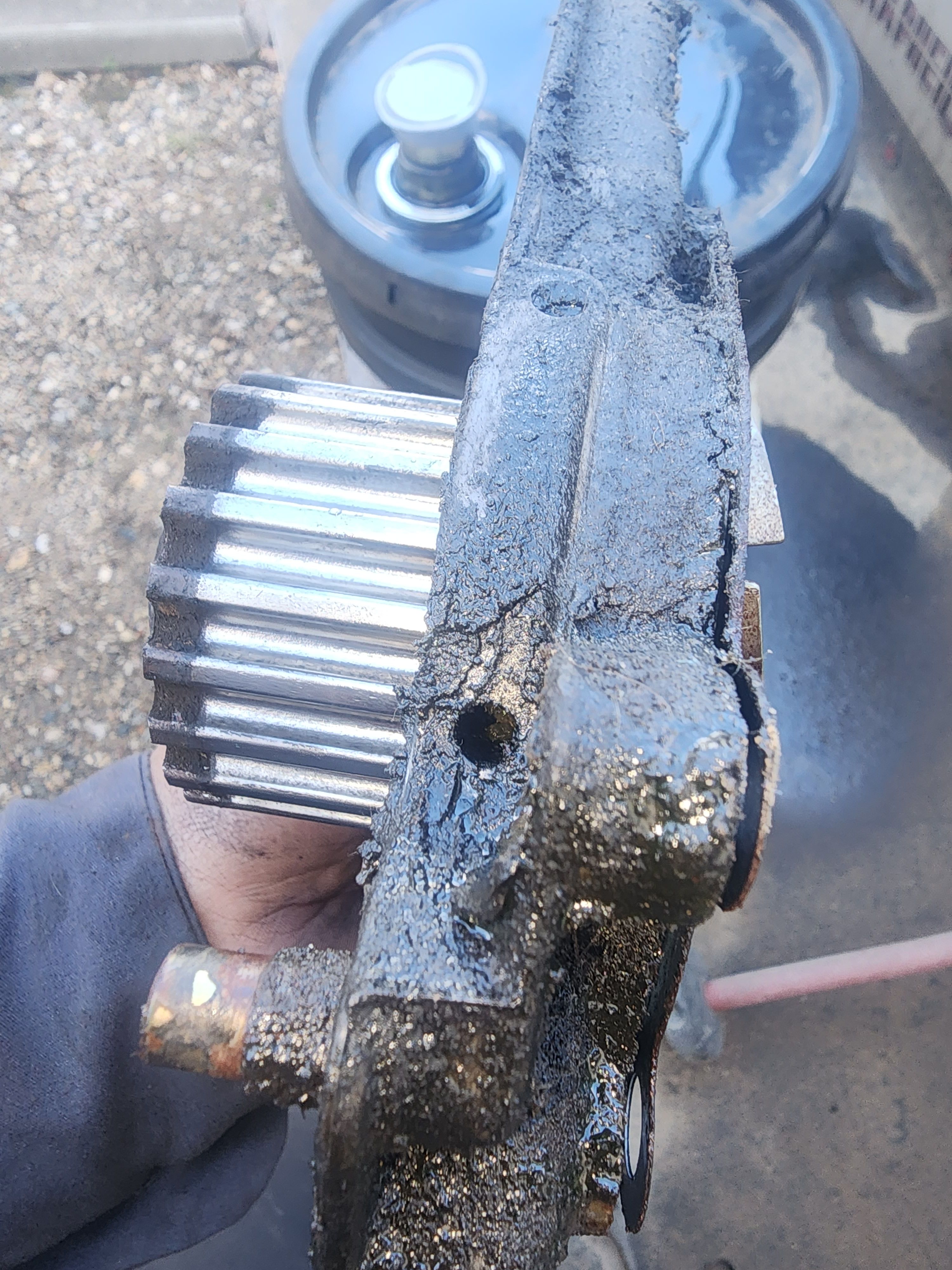 Close-up of the removed Yale forklift water pump, showing its toothed pulley and weep-hole area.