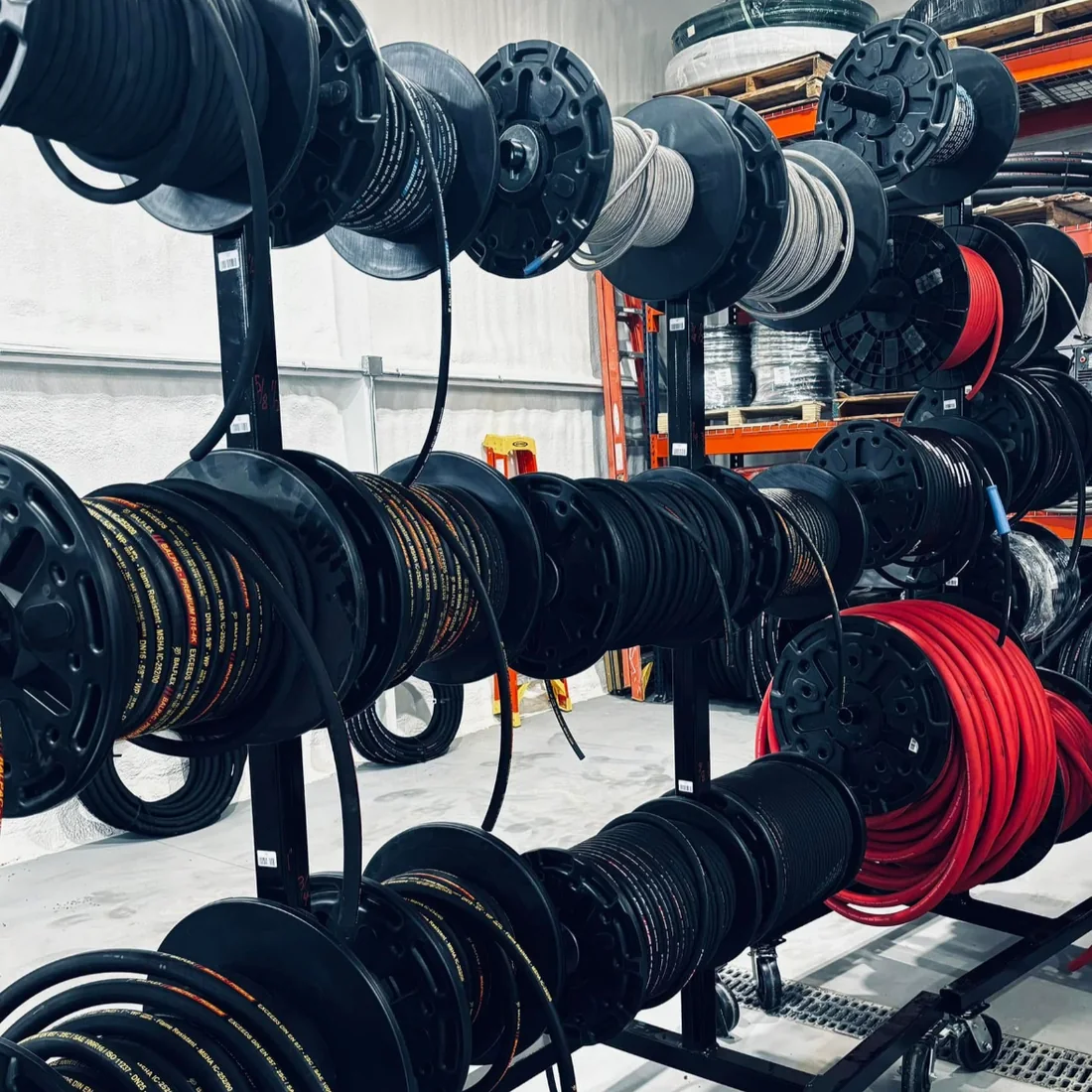 Hose reel rack holding hydraulic and industrial hose stock