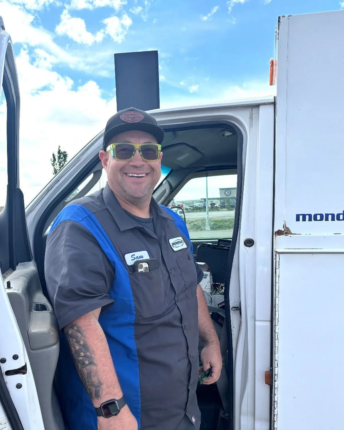 Mondak technician in uniform at the door of a service truck