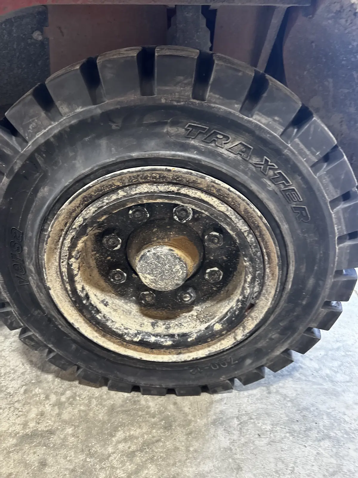 A worn solid tire on a forklift wheel, seen from the side